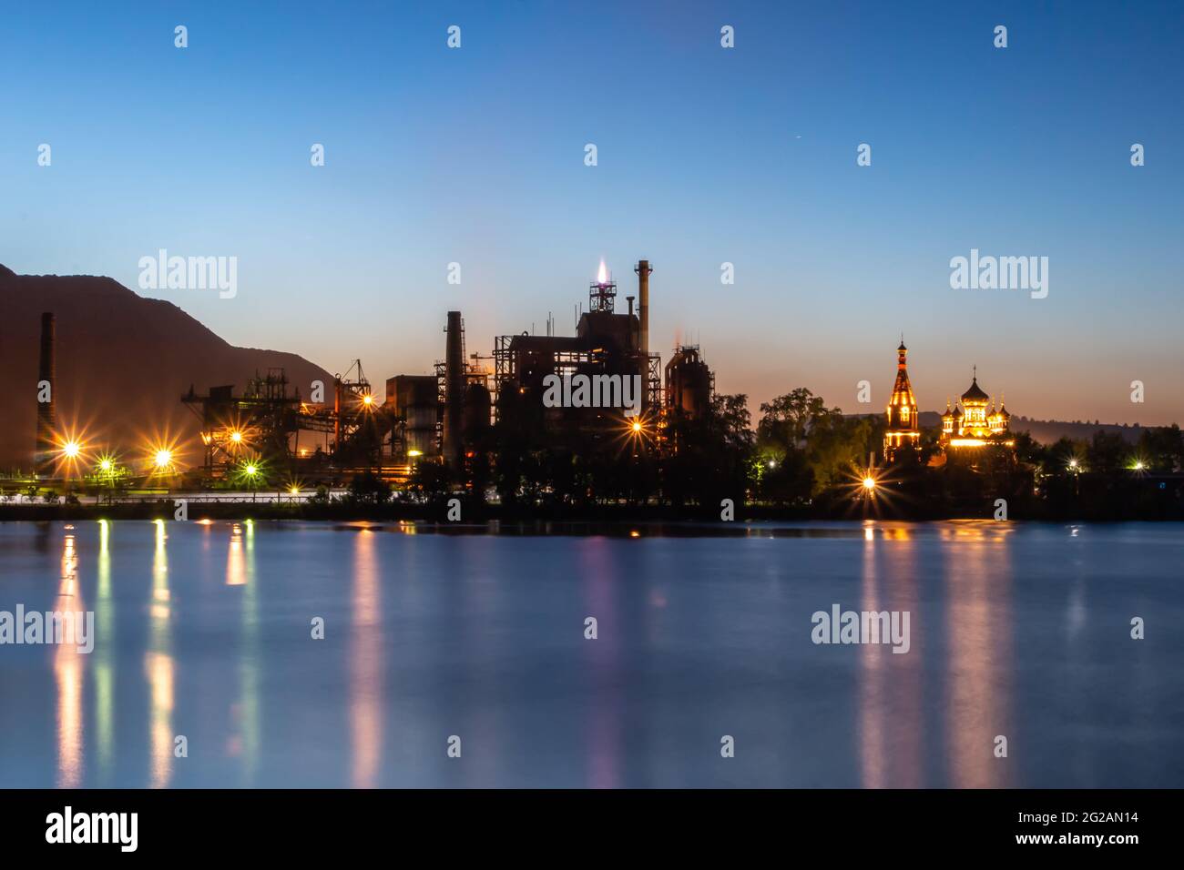 Impianto industriale vicino al lago in una notte estiva Foto Stock