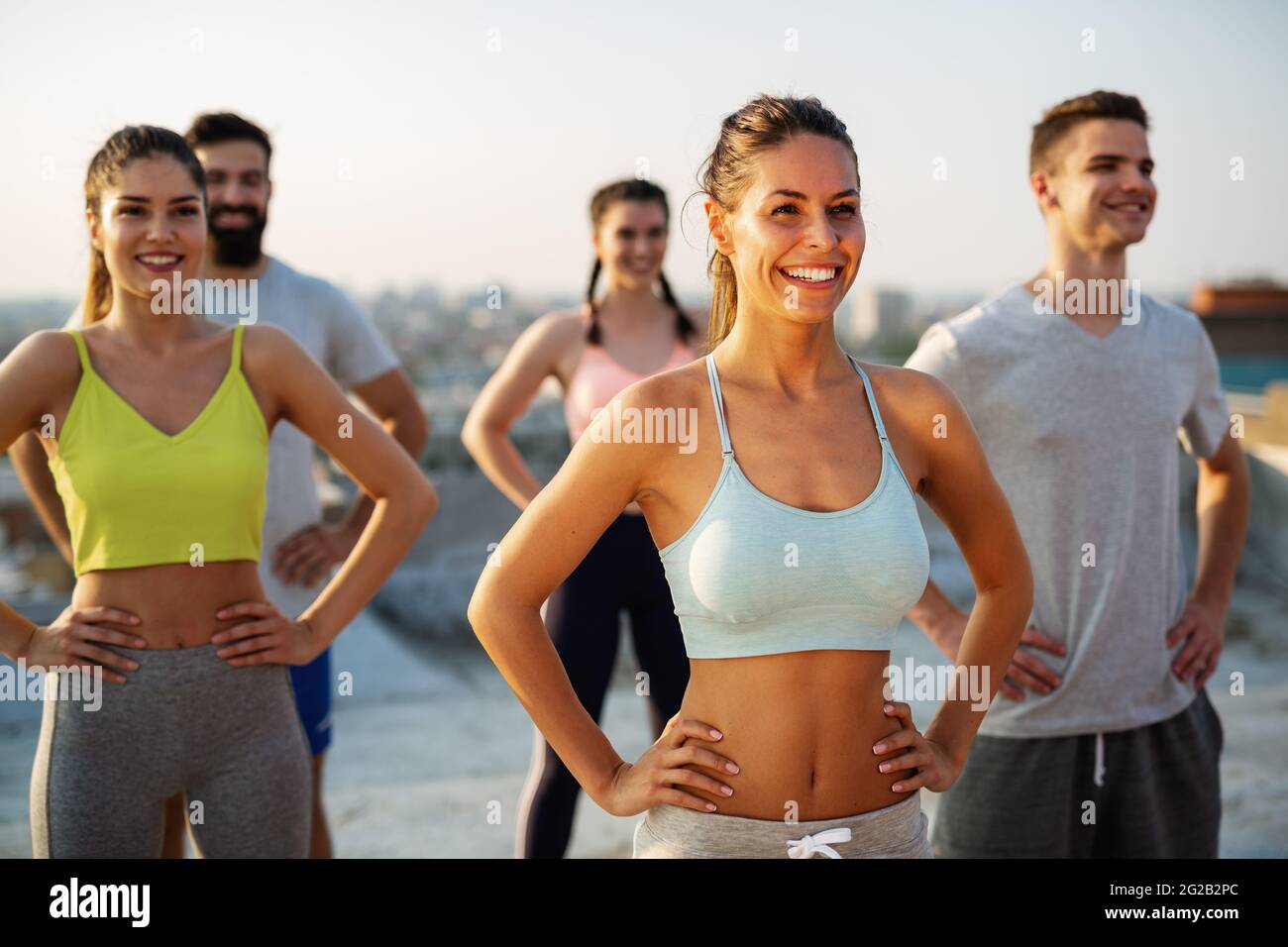 Gruppo di persone felici di fitness che si allenano insieme all'aperto, vivendo uno stile di vita sano e attivo Foto Stock