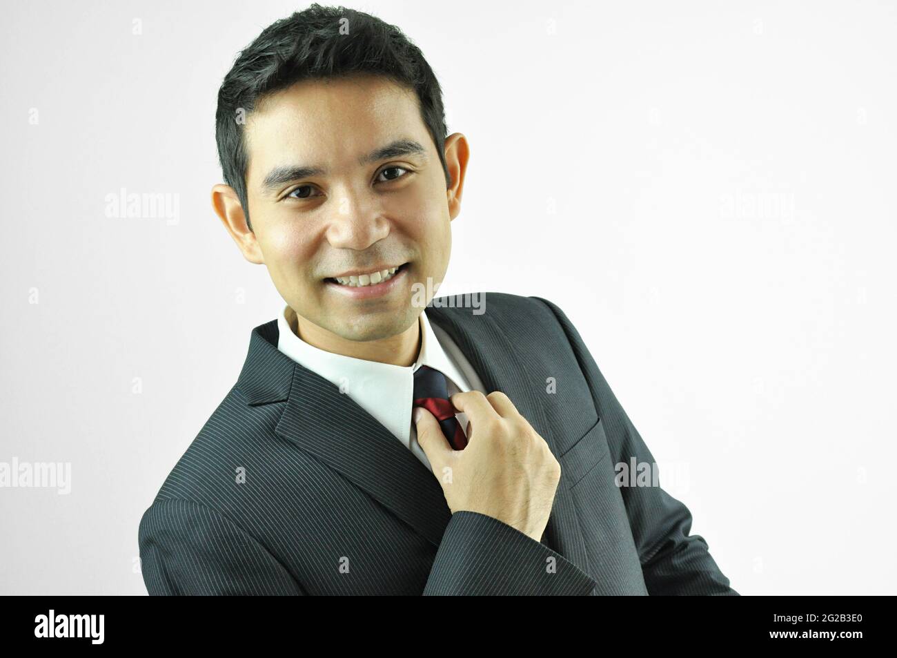 Uomo d'affari sorridente che ha riposto la nuca Foto Stock