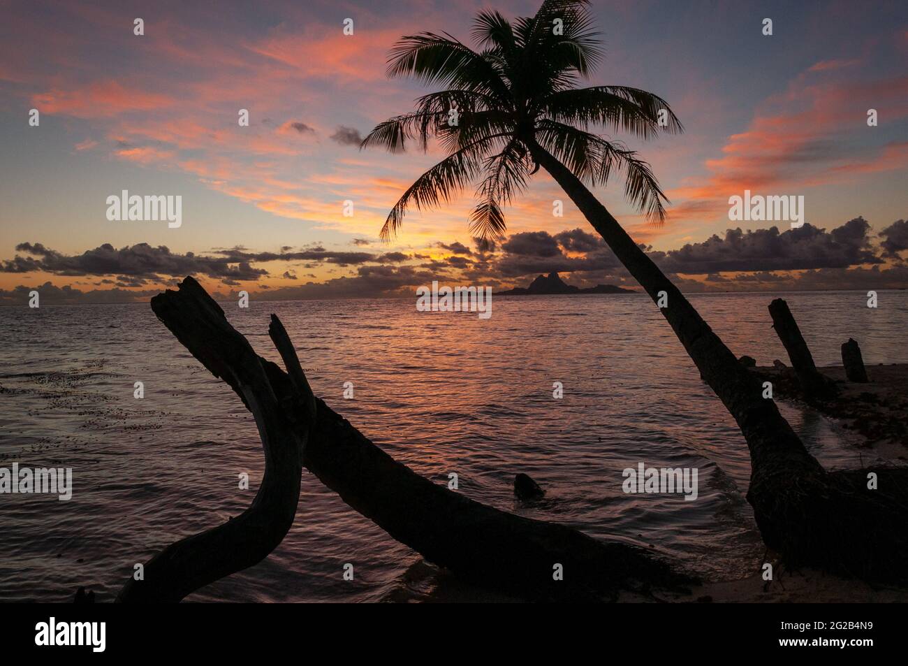 Tramonto polinesiano con l'isola di Bora Bora all'orizzonte Foto Stock