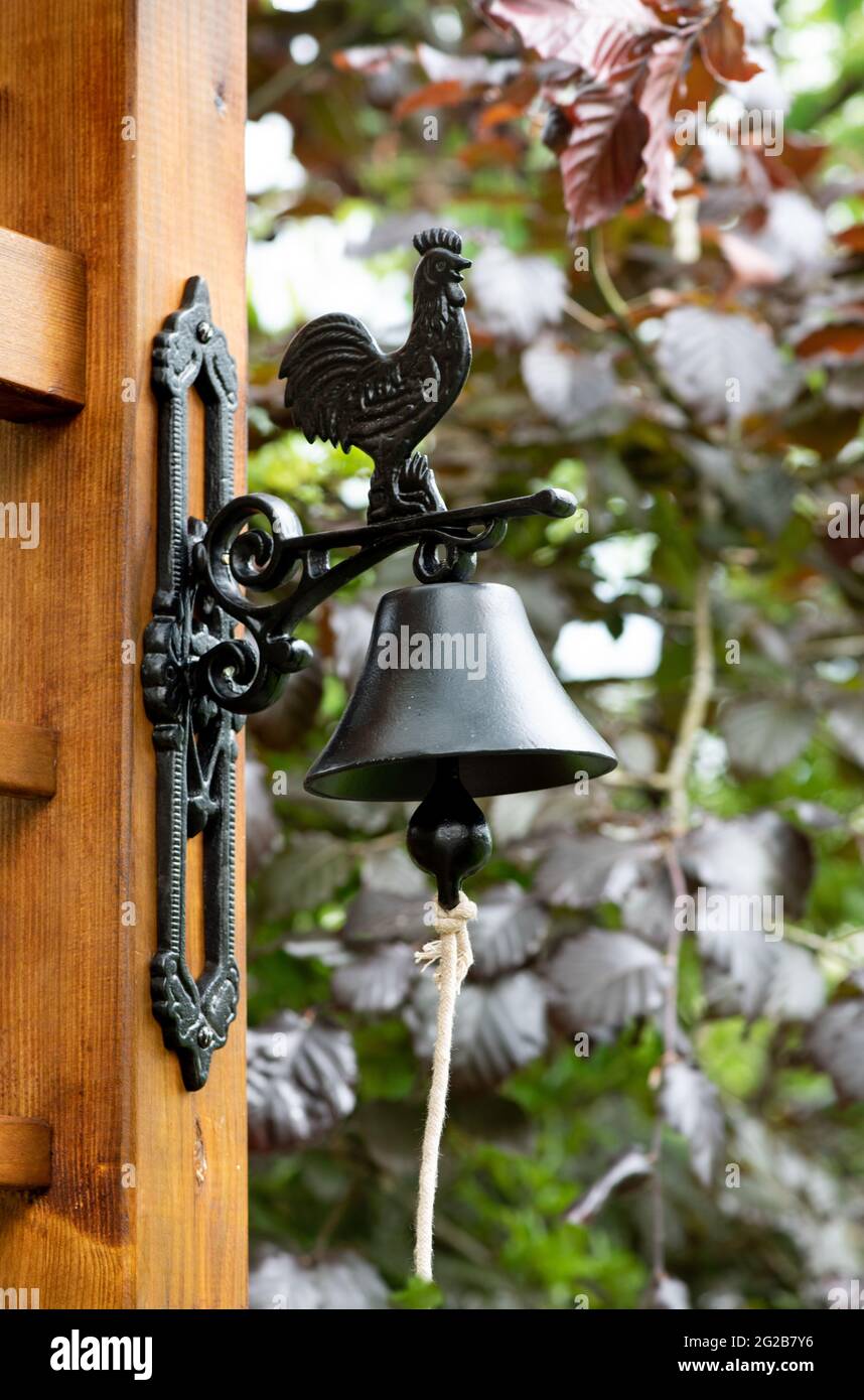 Interno esterno con recinzione in legno e campana in metallo nel giardino, Foto Stock