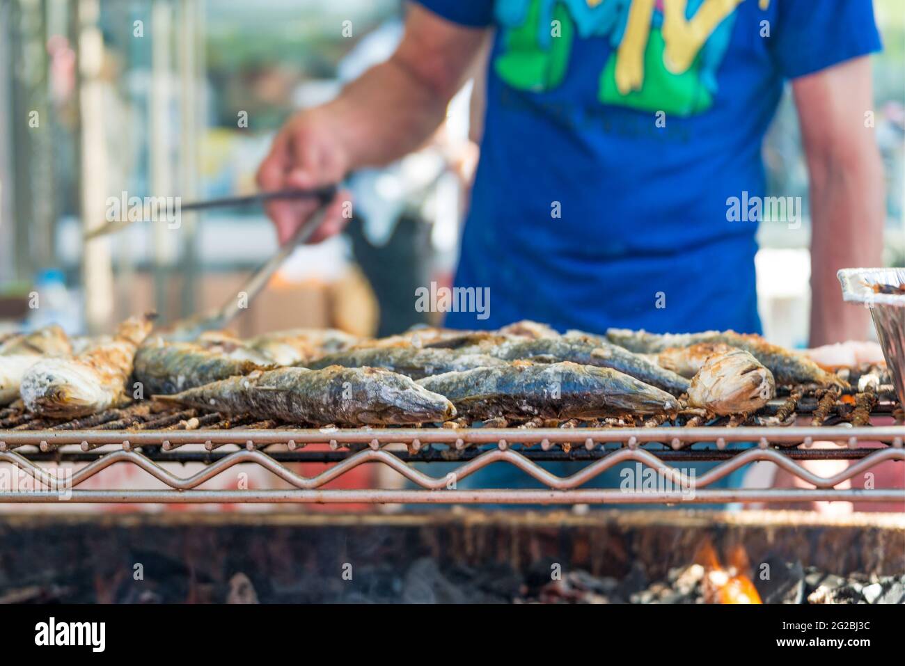 Uomo che cucina pesce su una griglia barbecue al festival Taste of Little Italy. Taste of Little Italy festival su College Street è una vivace strada annuale Foto Stock