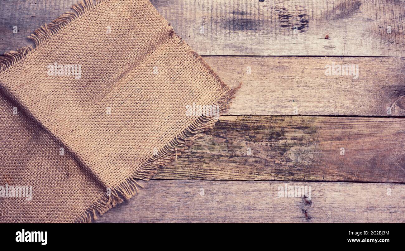 pezzo di tela con bordi strappati su uno sfondo di tavole di legno grigio, vista dall'alto Foto Stock