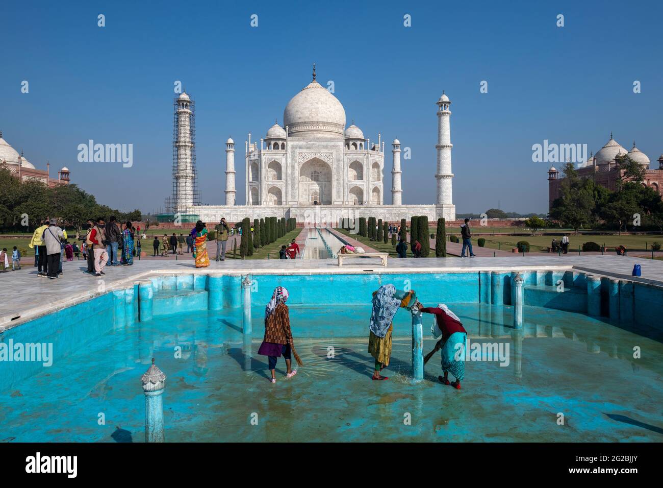 Lavoratrici in corso di pulizia di una delle piscine nel complesso Taj Mahal come monumento si apre per il pubblico dopo la prima ondata covid-19 in India. Foto Stock