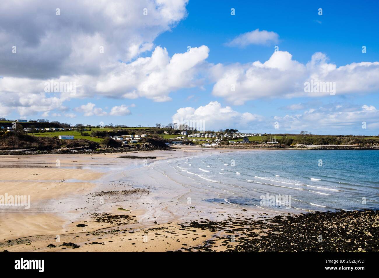 Vista su una tranquilla spiaggia di sabbia a bassa marea vista dal percorso costiero. Traeth Bychan, Bennlech, Isle of Anglesey, Galles, Regno Unito, La Gran Bretagna Foto Stock