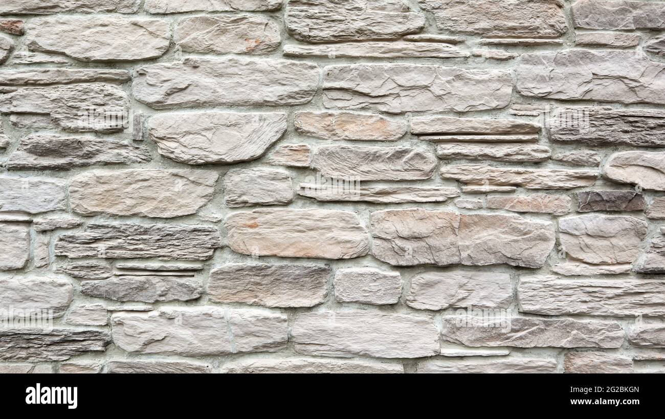 Pietra sfondo chiaro della struttura della parete come sfondo o struttura. Parte di un muro di pietra. Spazio di copia Foto Stock