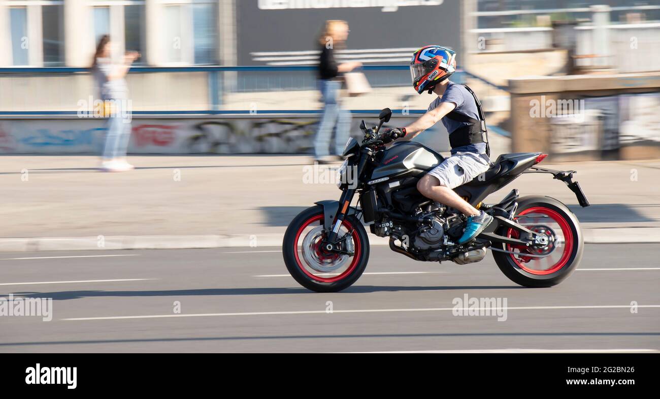 Belgrado, Serbia - 5 giugno 2021: Giovane uomo in moto veloce indossando pantaloncini e un protettore per la schiena , in città in una giornata di sole Foto Stock