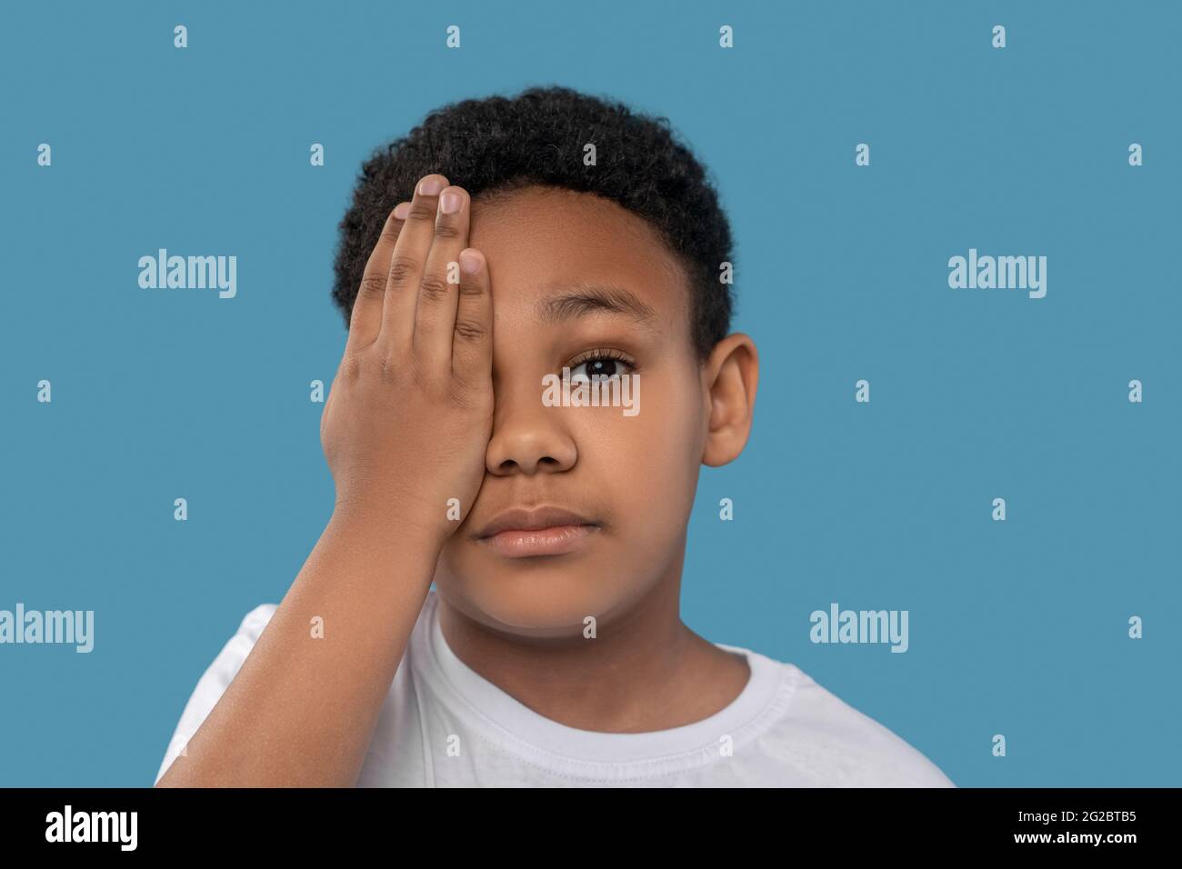 Ragazzo che copre un occhio con il palmo Foto Stock Ragazzo che copre un occhio con il palmo Foto Stock