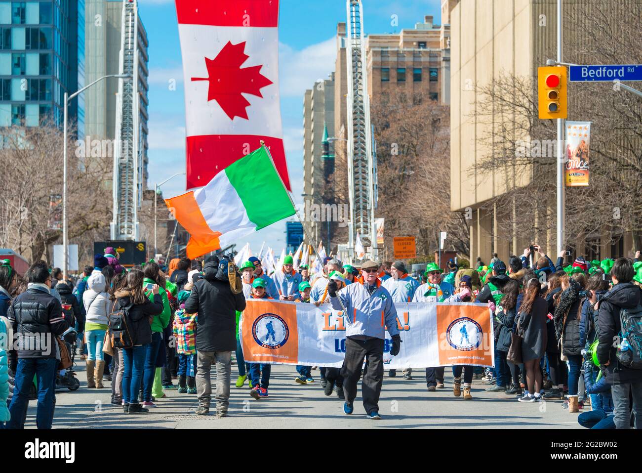Bandiera irlandese e bandiera canadese durante la 28° edizione della St. Patrick's Day Parade, la quarta più grande celebrazione del suo genere al mondo. Foto Stock