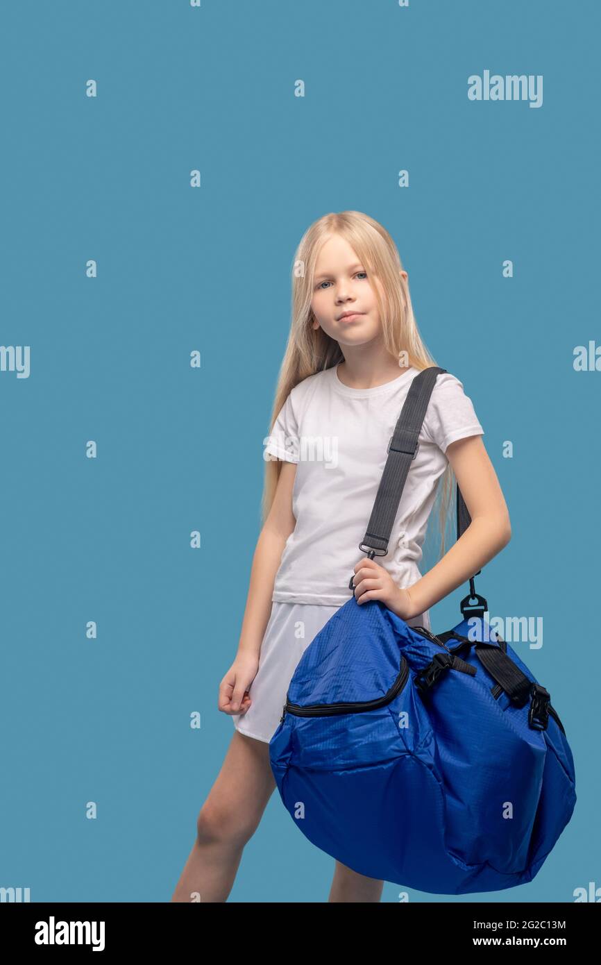 Ragazza in piedi in grande borsa sportiva sulla spalla Foto Stock