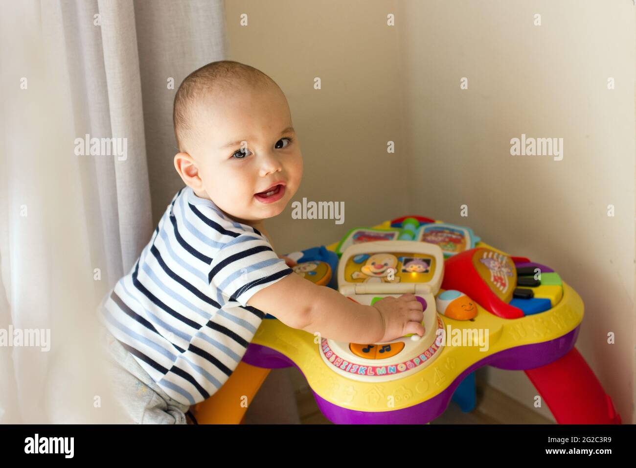 Felice bambino ragazzo sorridente che gioca giocattoli. Babyface primo piano Foto Stock