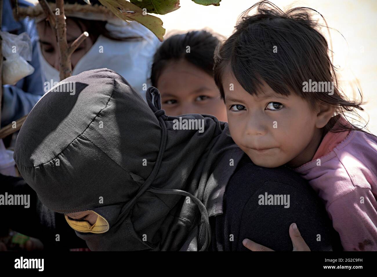 Madre e figlia Thailandia. Donna che indossa la maschera tradizionale e la copertura completa della testa come protezione contro il sole e l'inquinamento dagli elementi estremi Foto Stock