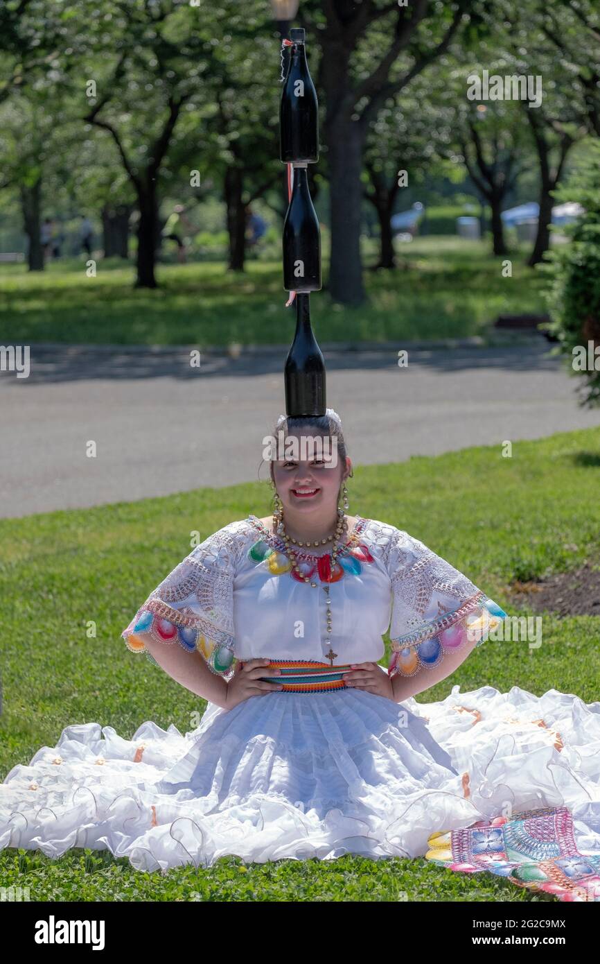 Un membro di un gruppo di ballo popolare Paraguayano Americano pone per le foto mentre equilibrano 3 bottiglie sul suo head.in Flushing Meadows Corona Park Foto Stock