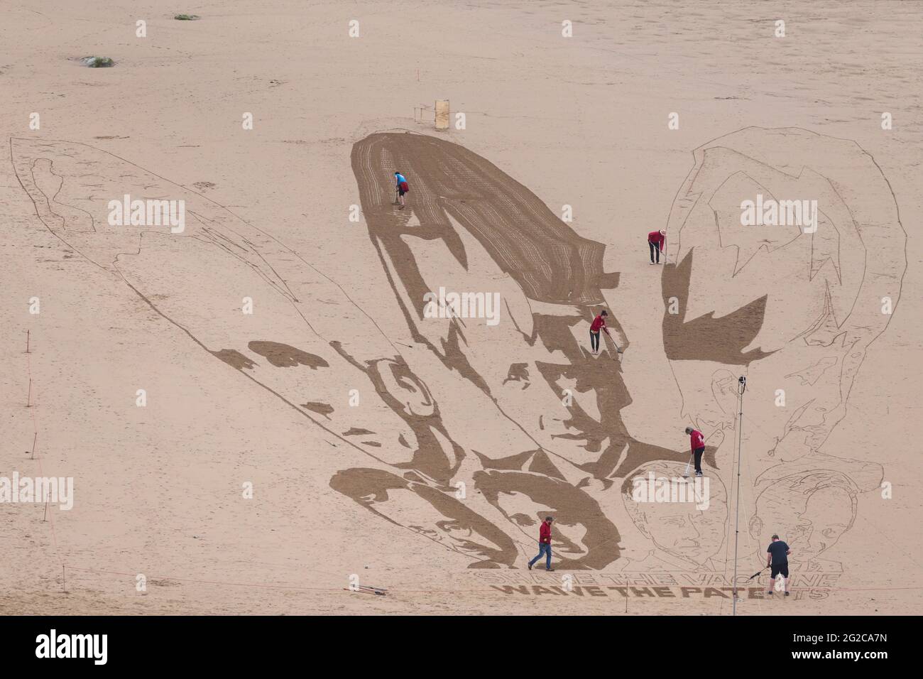 Il gruppo di campagna Avaaz crea una gigantesca opera d'arte sulla spiaggia raffigurante i volti dei leader del G7 insieme a un messaggio scritto nella sabbia con la scritta "Share il vaccino, waive the Patents", a Watergate Bay Beach, Newquay, Gran Bretagna, 10 giugno 2021. REUTERS/Tom Nicholson Foto Stock