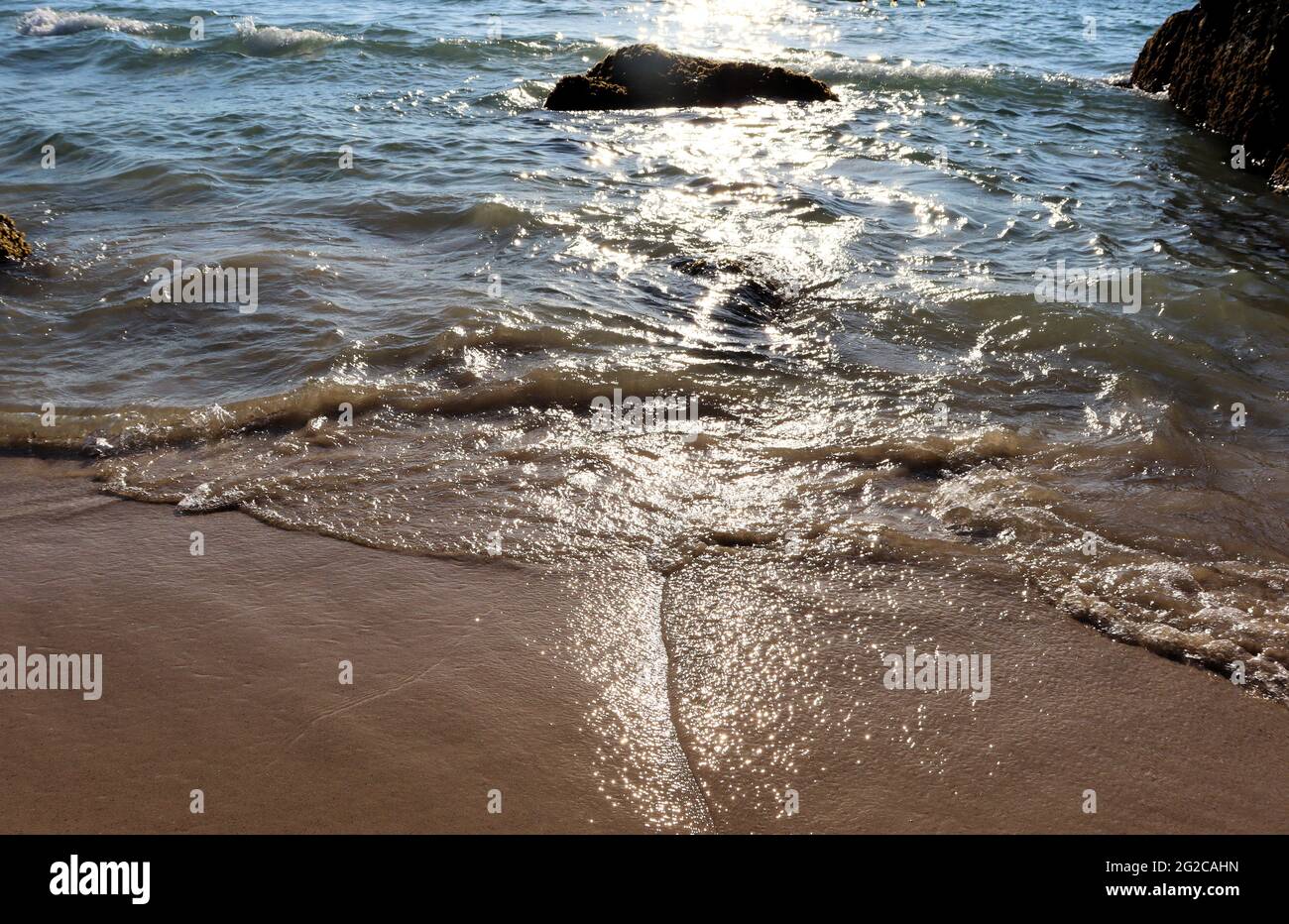 Calore al mare, onde glisten al sole, vacanza in spiaggia Foto Stock