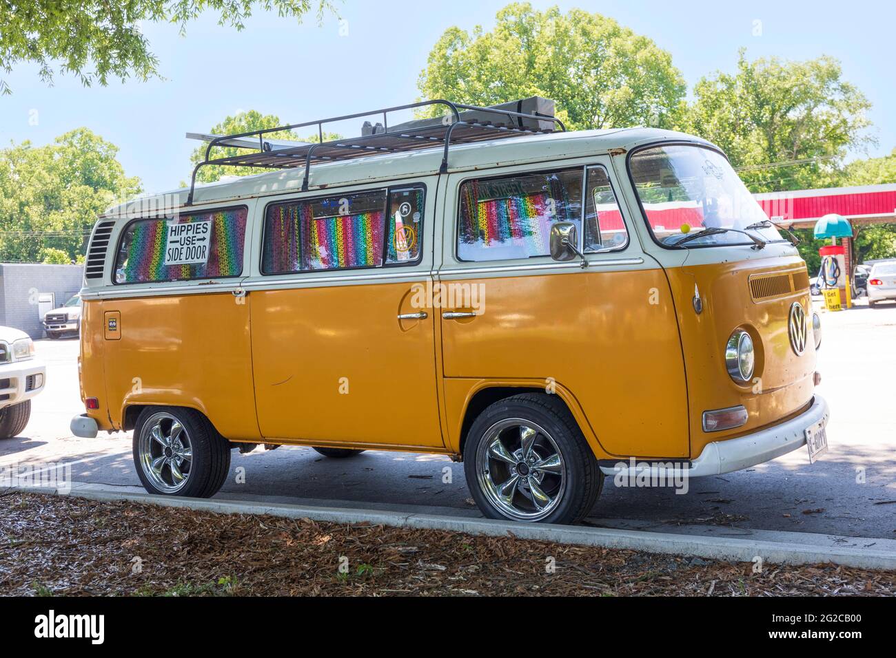 ELKIN, NC, USA-5 GIUGNO 2021: Un classico microbus Volkswagen, dotato di tende colorate coperte di simboli di pace, e un segno 'Hippies lato uso Foto Stock