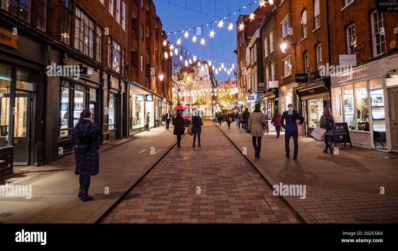 Seven Dials Christmas Shopping, Londra. Le luminose luci stagionali illuminano la notte del quartiere alla moda dello shopping nel centro di Londra. Foto Stock