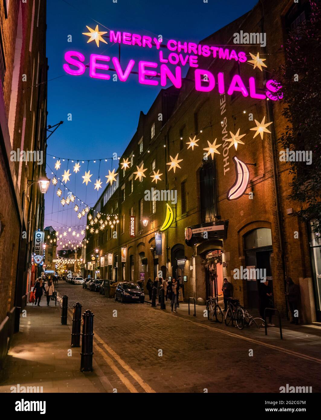 Sette Dials a Natale, Londra. Una vista notturna degli amanti dello shopping e delle luminose luci natalizie nel delicato quartiere alla moda dello shopping. Foto Stock