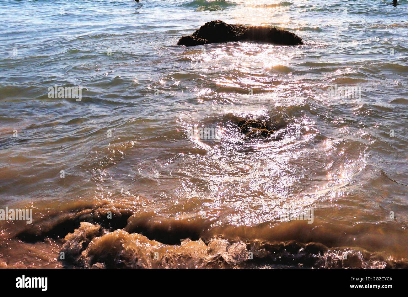 Calore al mare, onde glisten al sole, vacanza in spiaggia Foto Stock