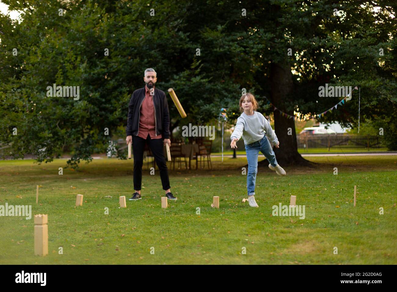 Padre e figlia che giocano gioco molkky nel parco Foto Stock