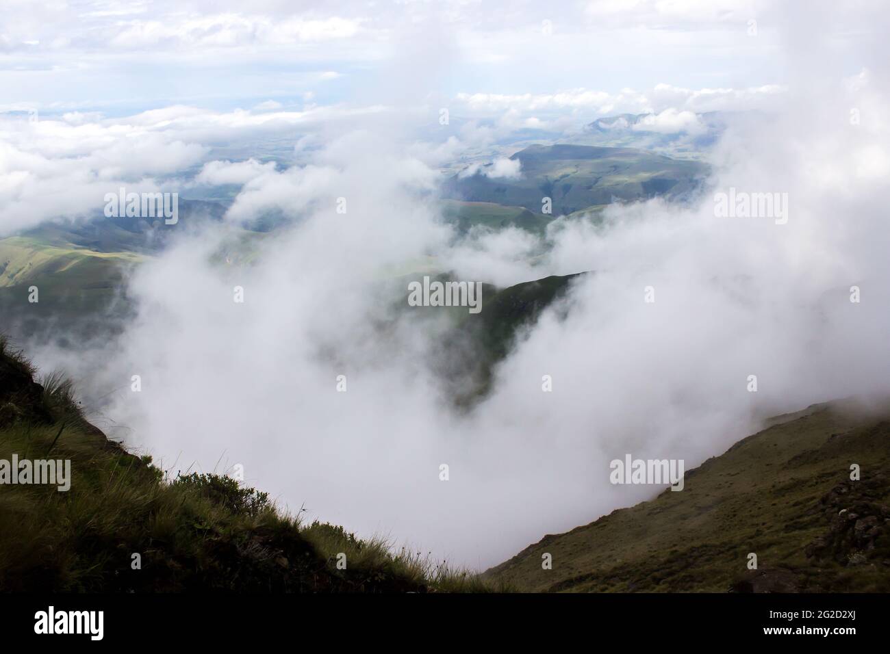 Si affaccia sulle valli ricoperte di nebbia dei Monti Drakensberg del Sud Africa, da uno dei passi di montagna più alti Foto Stock