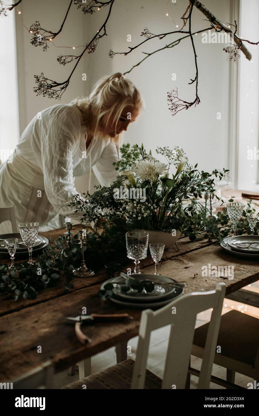 Donna che prepara decorazioni floreali per la festa Foto Stock