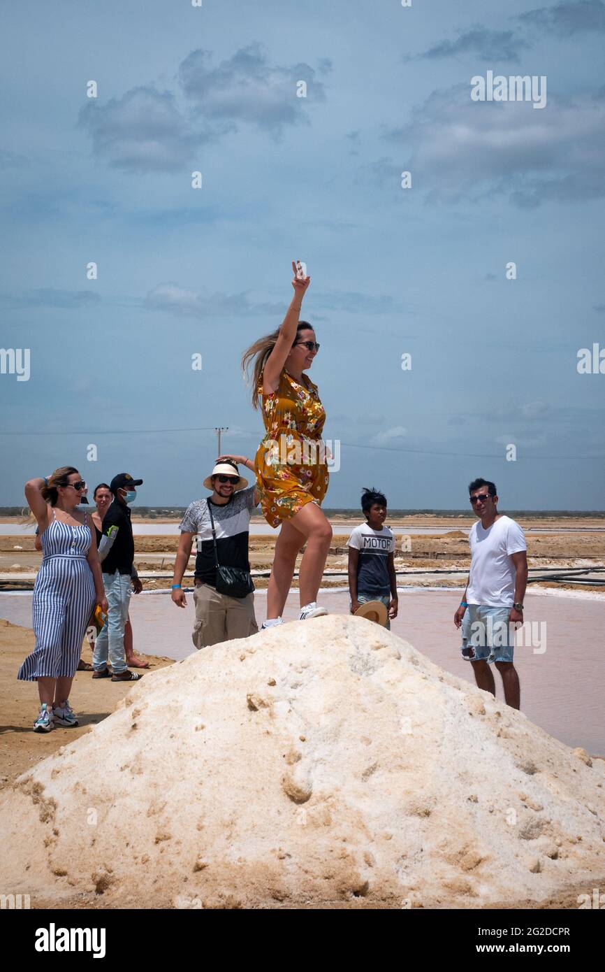 Manaure, la Guajira, Colombia - Maggio 29 2021: Giovane donna Latina nelle più importanti stecche di sale marittime del Paese, si trova in piedi in una mounta di sale Foto Stock