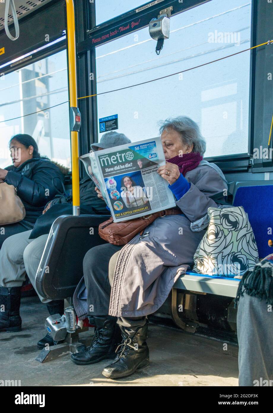 Una donna canadese che legge un giornale in un bus TTC sulle versioni contraddittorie che circondano la morte di Sgt. Andrew Joseph Dorion che è stato ucciso d Foto Stock