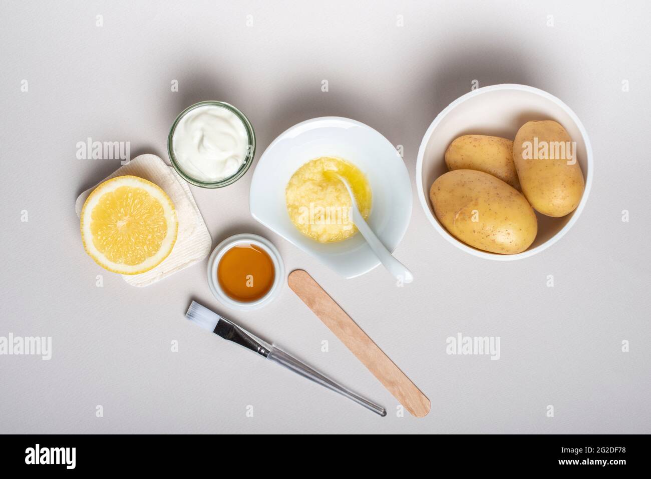 Ingredienti per le patate maschera viso: Patate, miele, limone, yogurt. Prodotto per la cura della pelle fatto in casa. Cosmetici fai da te. Disposizione piatta, vista dall'alto. Foto Stock