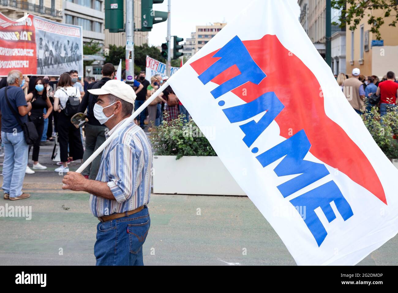 L'anziano protestore che ha detenuto la bandiera di un'Unione comunista del lavoro (Pame) durante lo sciopero generale ad Atene, in Grecia, contro la legge sul lavoro del governo Foto Stock