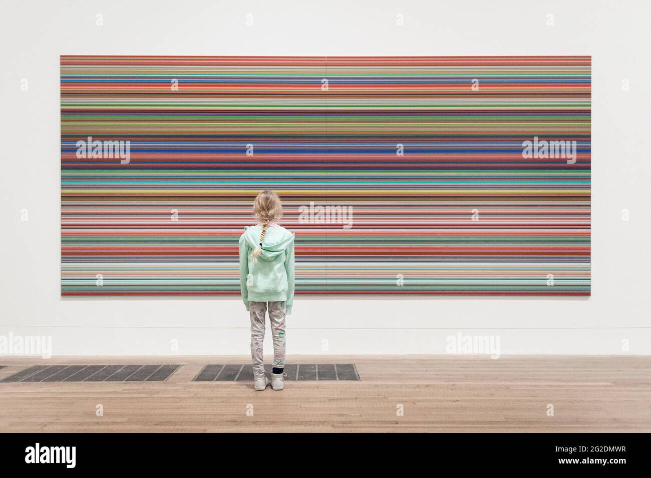 Una ragazza si trova di fronte a un grande dipinto di Bridget Riley nella Tate Modern Art Gallery. Foto Stock