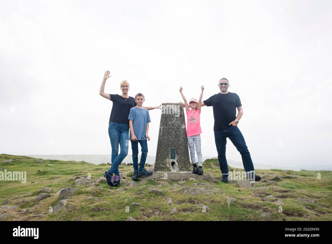 Una famiglia in piedi in un punto di trig su una passeggiata di campagna vicino a Ludlow, Shropshire. Foto Stock