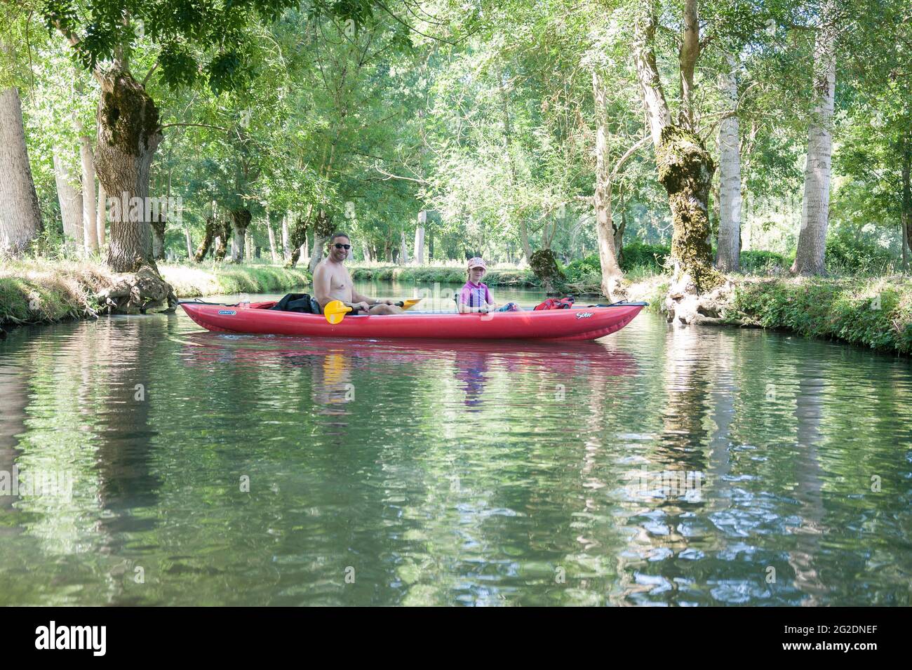 Una famiglia kayak nel Parco Naturale Regionale del Marais Poitevin su kayak gonfiabili in una vacanza estiva in Francia Foto Stock