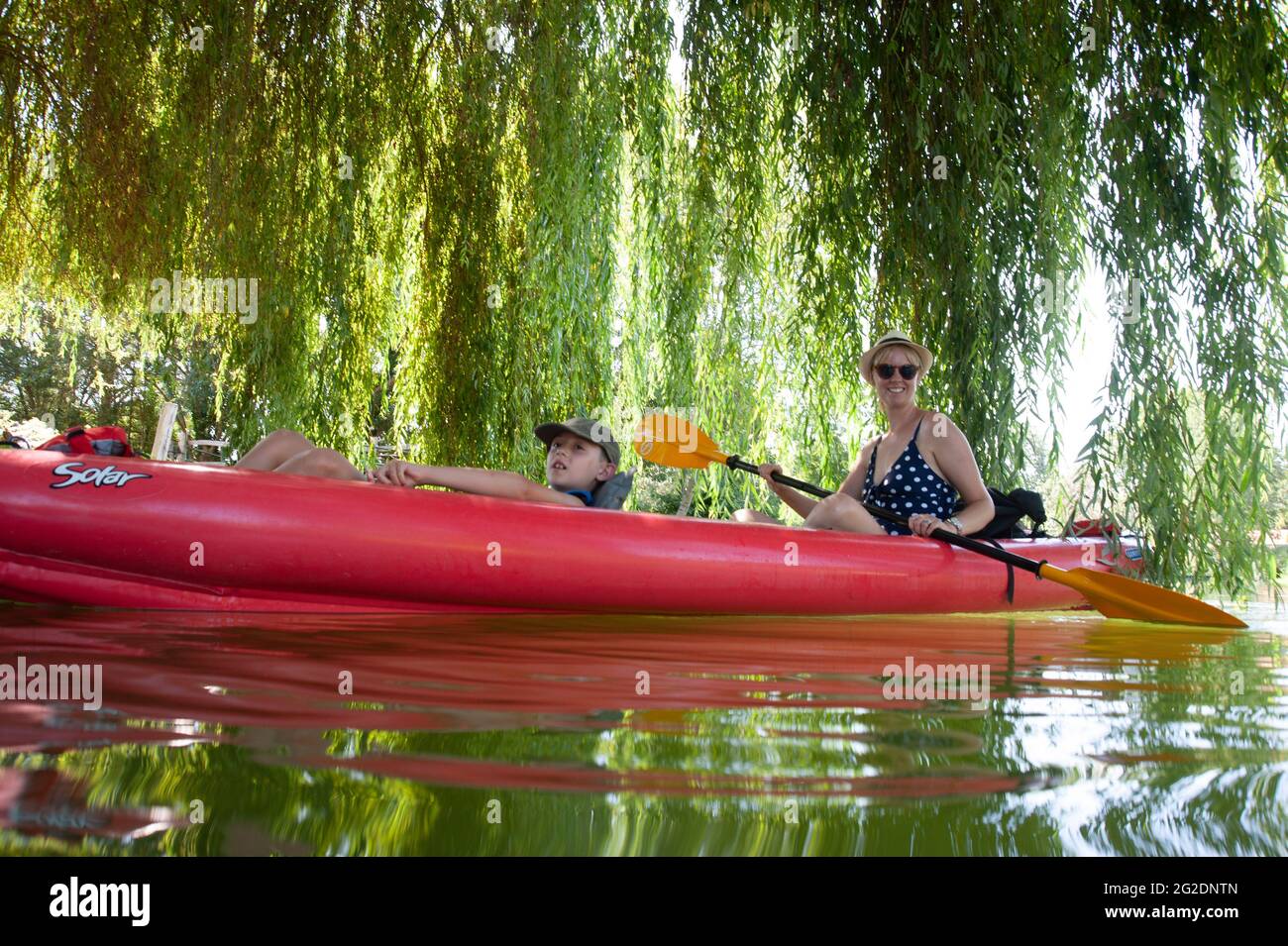 Una famiglia kayak nel Parco Naturale Regionale del Marais Poitevin su kayak gonfiabili in una vacanza estiva in Francia Foto Stock