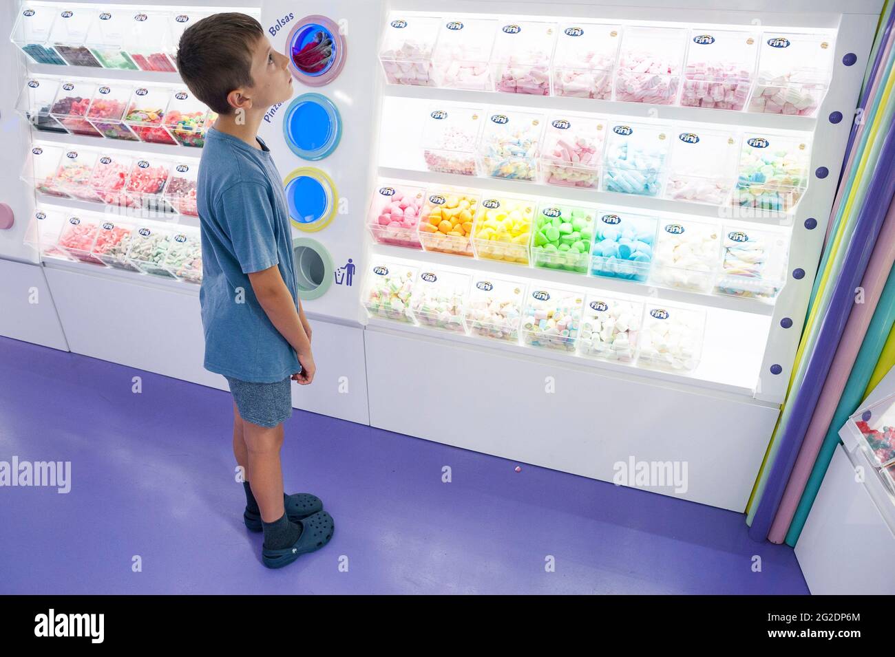 I bambini in un negozio di dolci che guarda la colorata esposizione di delizie Foto Stock