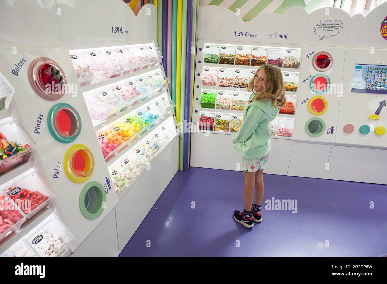 I bambini in un negozio di dolci che guarda la colorata esposizione di delizie Foto Stock