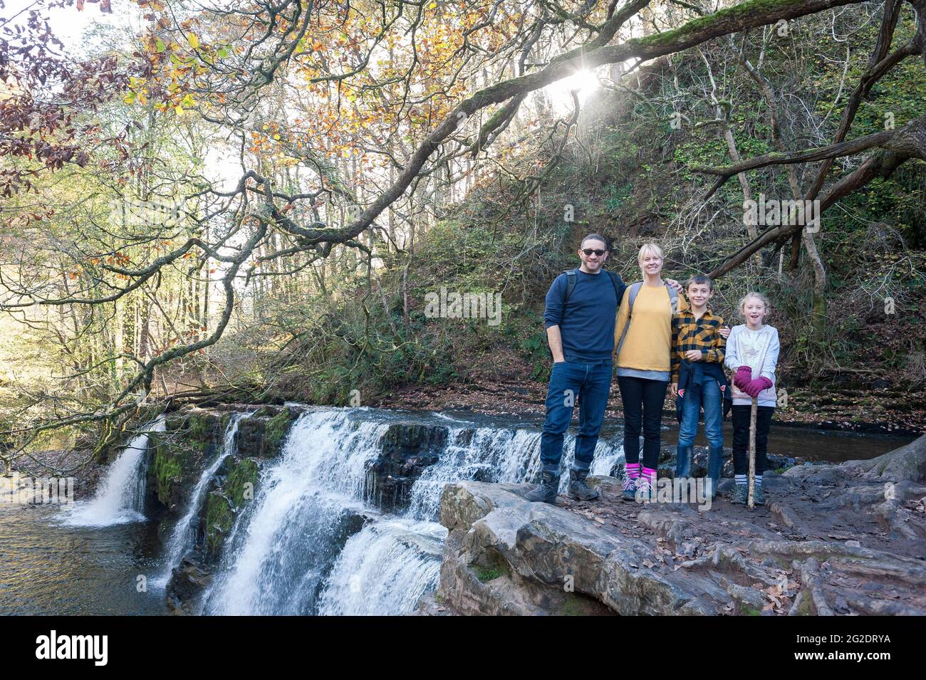 Una famiglia esplora le cascate in una lunga passeggiata nel galles. Foto Stock