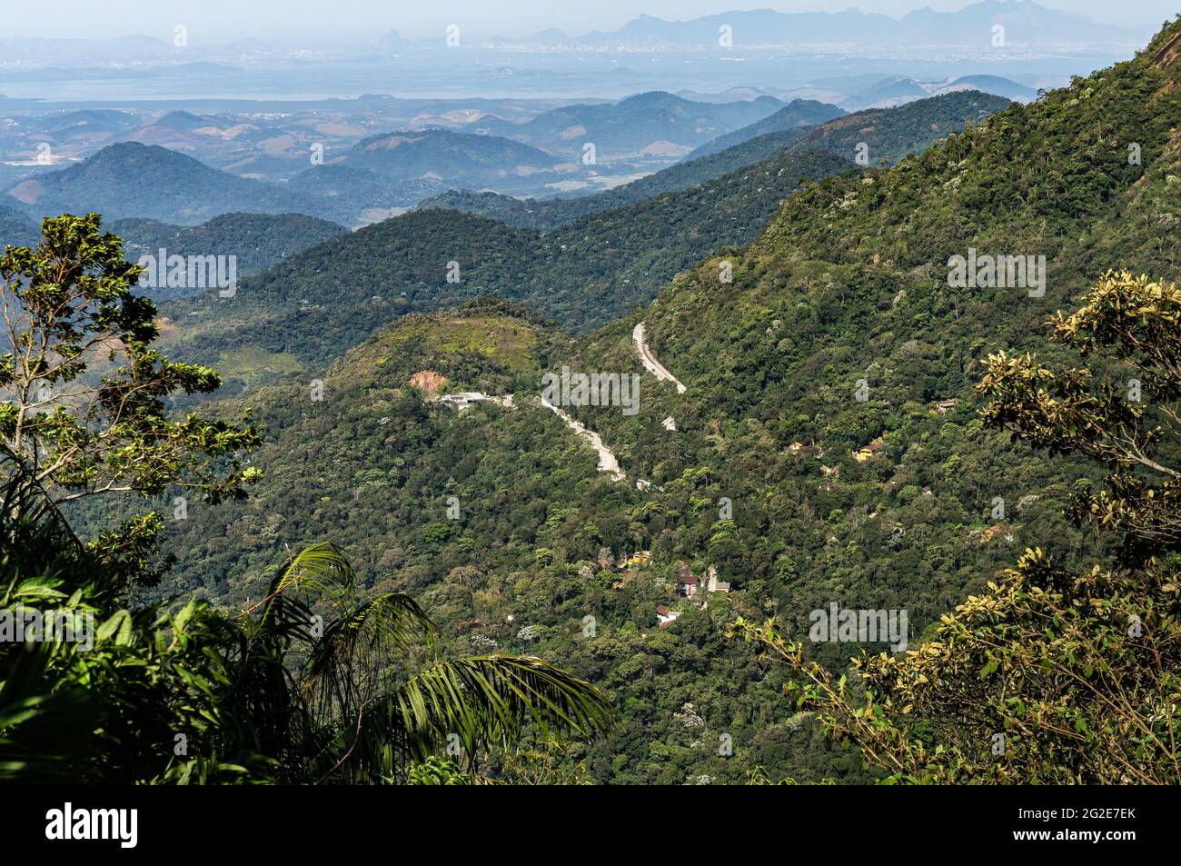 Vista dal Mirante do Soberbo punto di osservazione della tortuosa strada Rio-Teresopolis che corre attraverso la fitta vegetazione verde delle montagne di Organ Range. Foto Stock