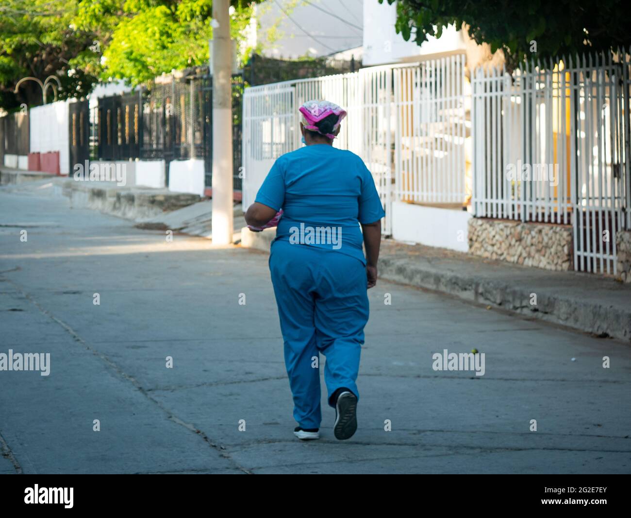 Santa Marta, Magdalena, Colombia - Maggio 22 2021: Donna Latina vestita in azzurro con un copricapo cammina nel mezzo della strada presto nel Morn Foto Stock