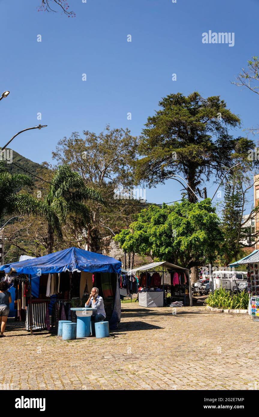 Tende da Alto Fair (mercato pubblico aperto) in uno degli angoli di piazza Higino da Silveira con alberi dietro e sotto cielo azzurro chiaro giorno. Foto Stock