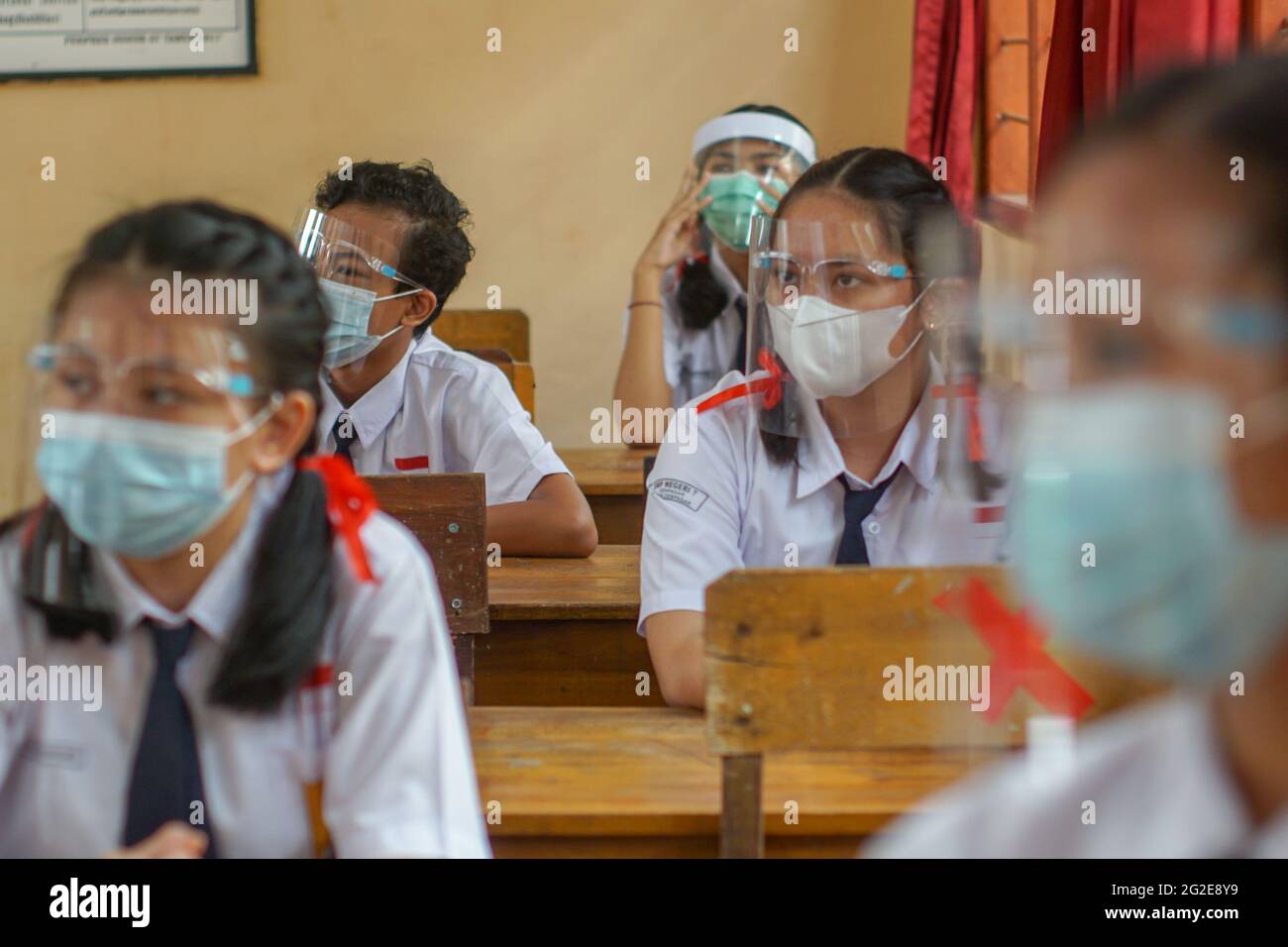 BALI, INDONESIA-MAGGIO 18 2021: Gli studenti in Indonesia stanno seguendo il processo di apprendimento in classe utilizzando faceshield e maschere di salute per implementare la salute p Foto Stock