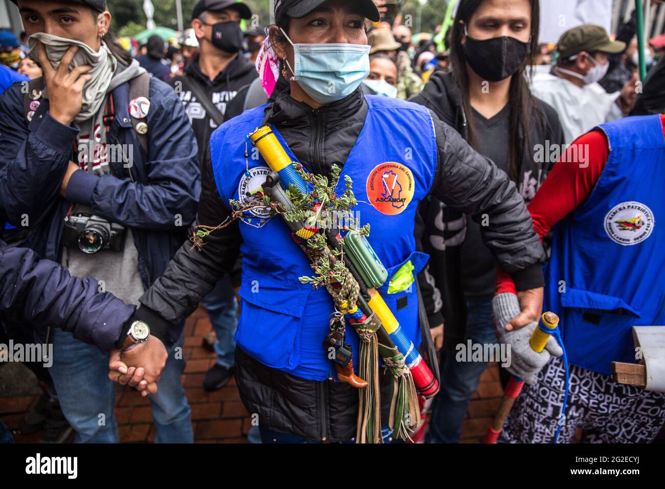 Una donna membro della 'Guardia contadina' tiene le mani per formare un cerchio per proteggere i manifestanti di fronte al Tequendama Hotel durante la manifestazione.la Commissione interamericana per i diritti umani (CIDH) ha incontrato la Corte Suprema di giustizia, il Consiglio di Stato, la Corte costituzionale, Il Consiglio superiore della magistratura e la giurisdizione speciale per la pace. La partecipazione di due "guardie dei contadini" e della "prima linea" è stata fondamentale per mantenere l'ordine tra dimostranti e polizia nazionale, nello stesso giorno il comitato di sciopero nazionale colombiano ha chiesto ai dimostranti di "prendere il controllo di Bogotà". Foto Stock