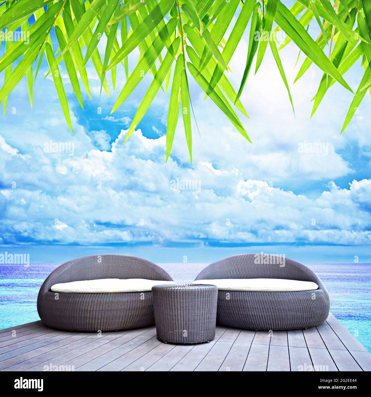 Rilassante salotto in rattan sul mare blu Foto Stock