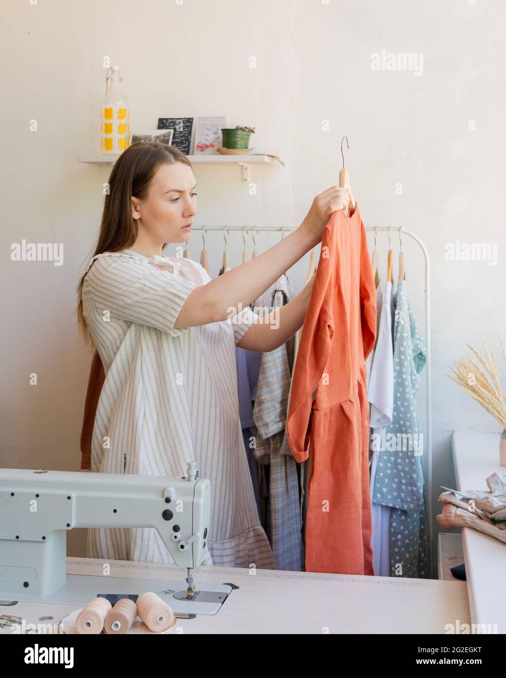 Donna specializzata nel settore dell'abbigliamento locale con un abbigliamento appena cucito Foto Stock
