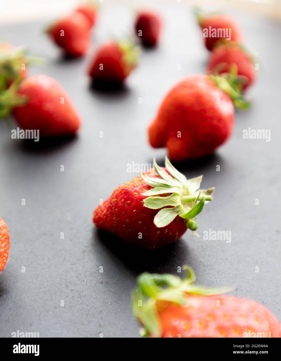 Fragole mature su fondo nero, frutti di bosco estivi Foto Stock