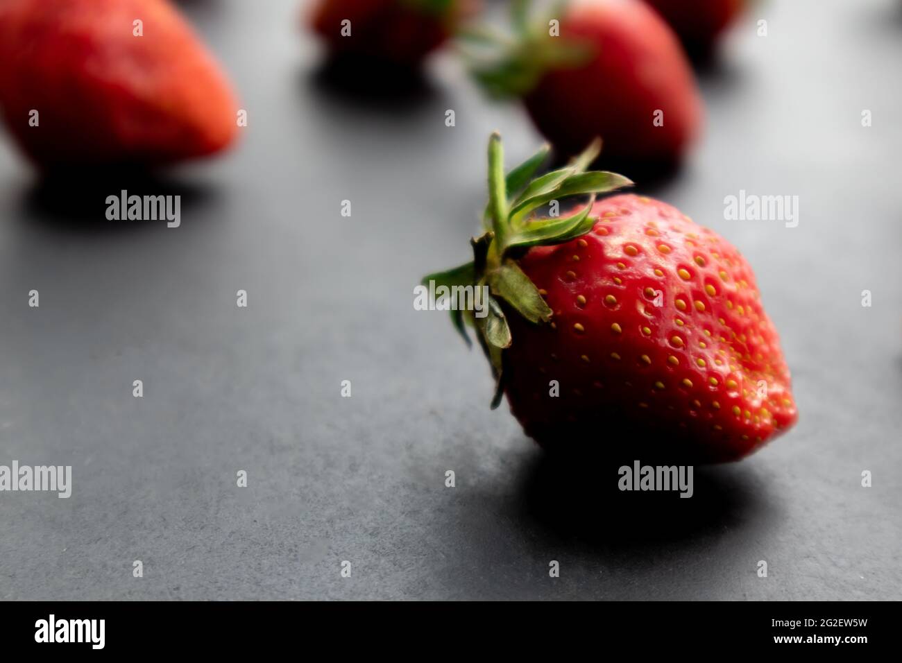 Fragole mature su fondo nero, frutti di bosco estivi Foto Stock