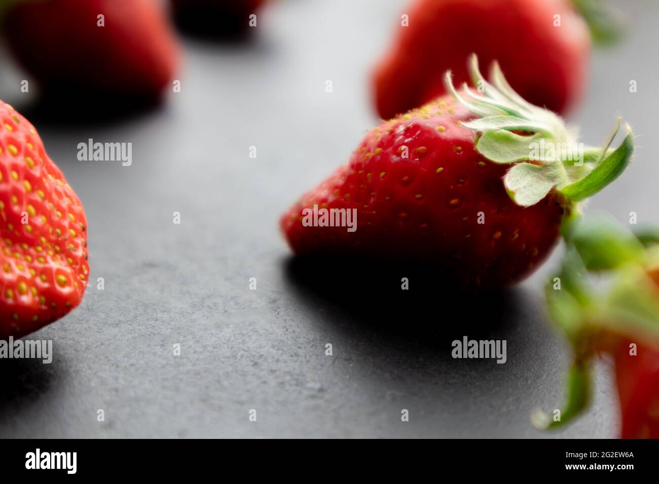 Fragole mature su fondo nero, frutti di bosco estivi Foto Stock
