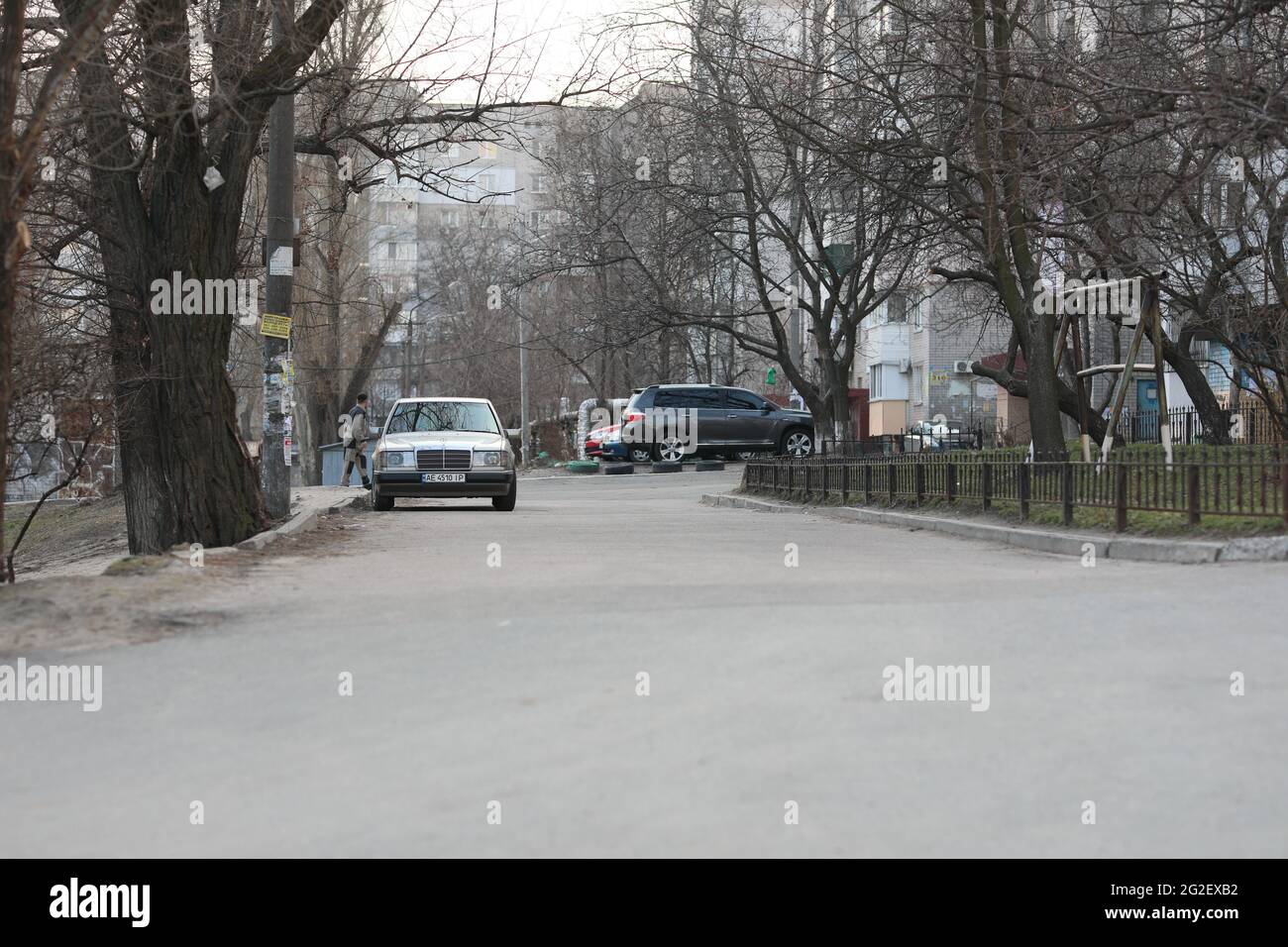 Una strada con auto parcheggiate sul lato di una strada Foto Stock