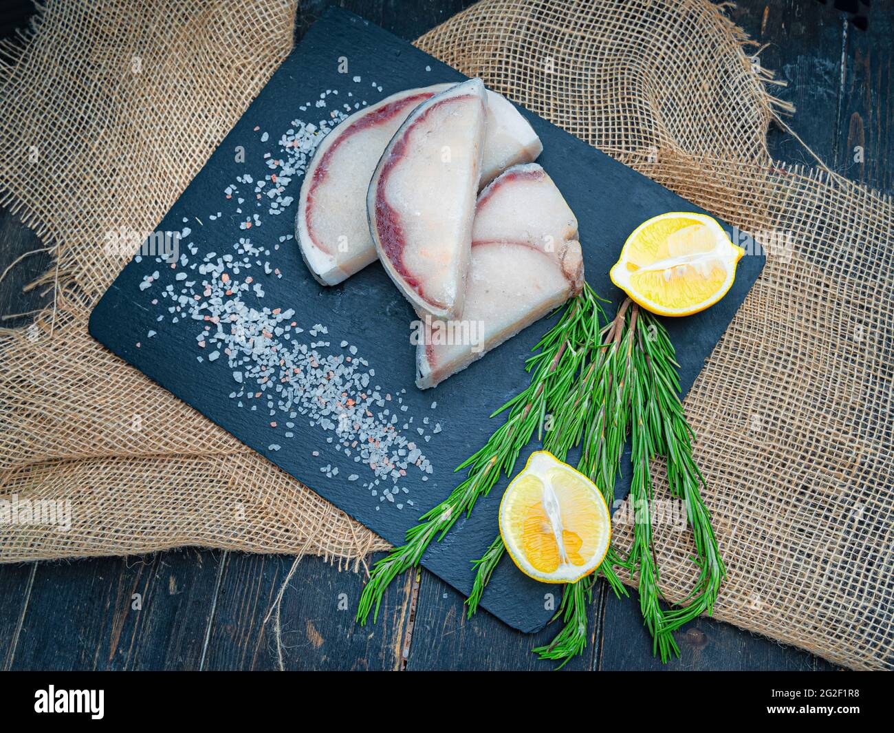 Bistecche fresche di squalo blu non cotte con limoni e rosmarino Foto Stock