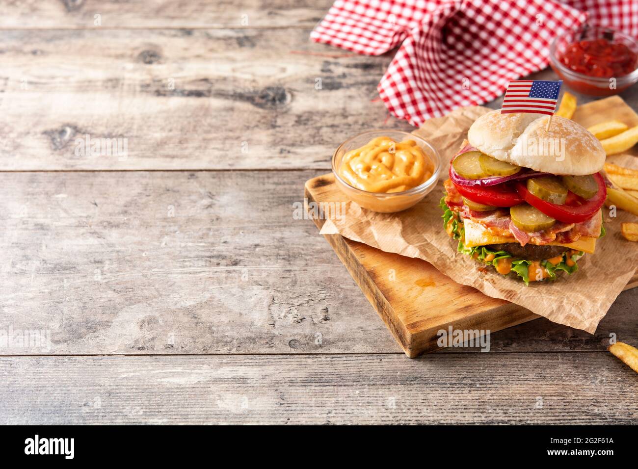 Hamburger di manzo con pancetta su tavolo di legno Foto Stock